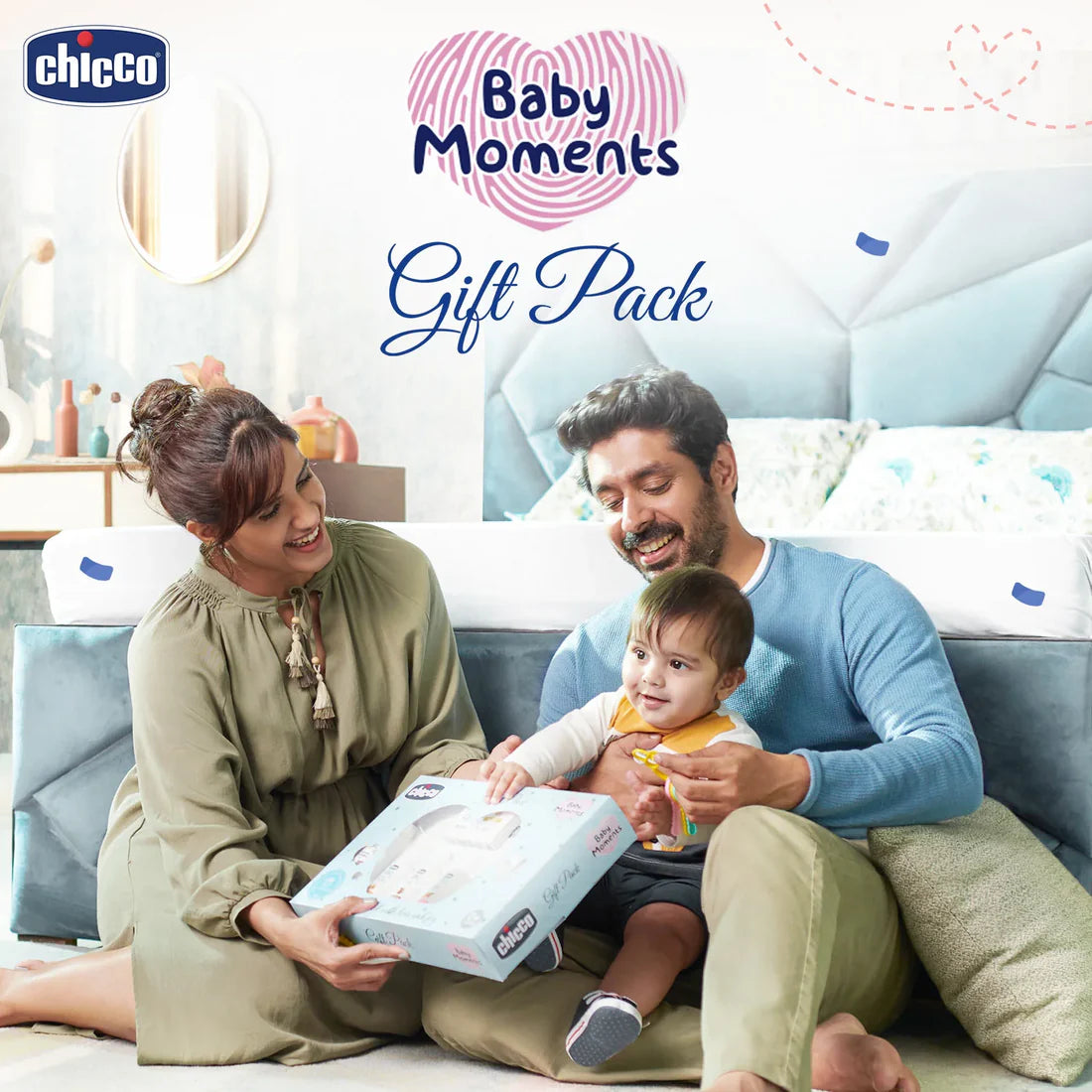 Family with a baby sitting on a couch, holding a Chicco product, with 'Baby Moments' and 'Chicco' branding. Chicco Baby Moments Essential Set Gift Set for Babies 0M+ Blue go littles product image 7
