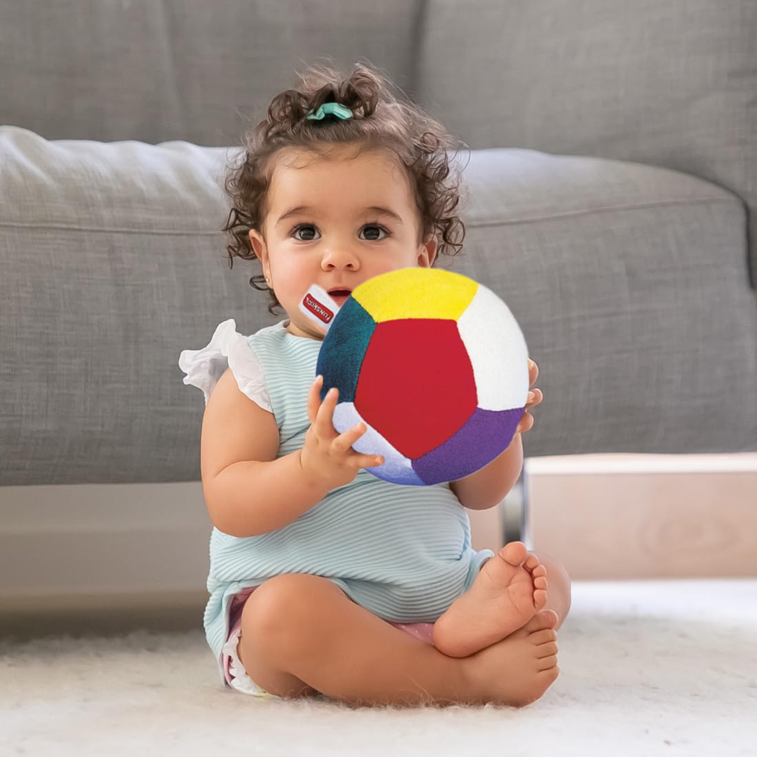 Funskool Giggles Soft Ball at Go Littles product image 3. Baby holding a colorful ball on a couch